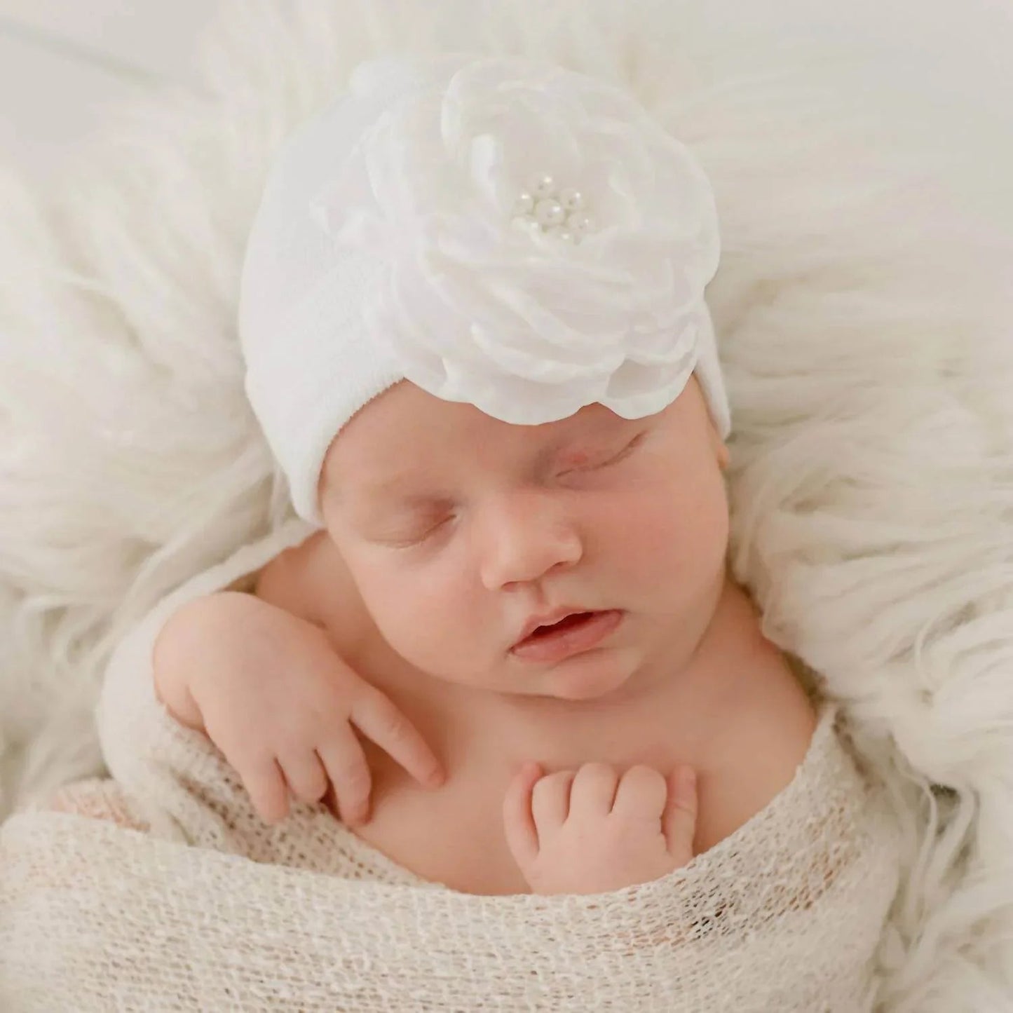 Babyhaube mit Seidenblumen- und Perlenakzenten
